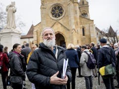 Auf dem Platz der Kollegiatskirche in Neuenburg versammelten sich die Unterstützer des Pastors Norbert Valley (vorne). (Bild: Keystone/JEAN-CHRISTOPHE BOTT)