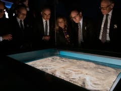 Bundesrat Alain Berset, flankiert von Vertretern der St. Galler Regierung, betrachtet den St. Galler Klosterplan in der soeben eröffneten Ausstellung «Das Wunder der Überlieferung». (Bild: KEYSTONE/GIAN EHRENZELLER)