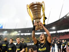 Im Letzigrund stemmt Kevin Mbabu schon einmal den Meisterpokal in die Höhe (Bild: KEYSTONE/ANTHONY ANEX)