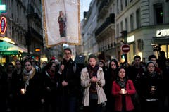 Menschen bei einer Prozession zur Kirche am Dienstagabend. (AP Photo/Kamil Zihnioglu)