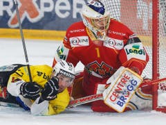 Biels Torhüter Jonas Hiller im Bodenkampf mit dem Berner Tristan Scherwey (Bild: KEYSTONE/PETER KLAUNZER)