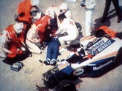 Sicherheitskräfte versuchen Ayrton Senna zu helfen - vergeblich. Am Abend des Unfalltags wurde der Tod der Ikone verkündet (Bild: KEYSTONE/AP TV TOKYO)
