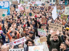 Dasitzen und nichts tun nützt nichts: Demonstrationszug mit Transparenten in Zürich. (Bild: KEYSTONE/ENNIO LEANZA)