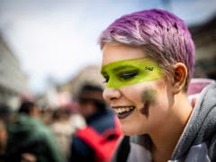 Farbe und ein Lächeln müssen auch sein: Junge Frau an der Klimademo in Lausanne. (Bild: KEYSTONE/EPA KEYSTONE/VALENTIN FLAURAUD)