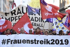 Kundgebungsteilnehmer laufen in Zürich im Zeichen des Frauenstreiks. (KEYSTONE/Ennio Leanza)