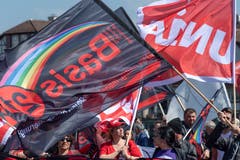 Fahnen der Gewerkschaften Unia und Basis 21 am Demonstrationszug in Basel. (KEYSTONE/Georgios Kefalas)