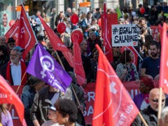 Am Tag der Arbeit sind etwa in Genf neben den roten auch violette Fahnen im Umzug zu entdecken. Sie stehen für die Forderungen nach Lohngleichheit zwischen Mann und Frau. (Bild: KEYSTONE/MARTIAL TREZZINI)