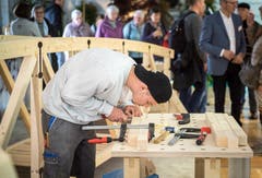 Ein Lehrling arbeitet konzentriert zwischen den Messebesuchern. (Bild: Reto Martin)