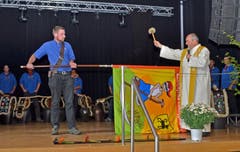 Pfarrer Josef Manser tauft und segnet die Fahne der Landjugend Alttoggenburg, die ihm der Fähnrich reicht. (Bild: Peter Jenni)