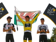 Jubeln die Sieger der Tour de France womöglich bald in ihren National- statt Teamfarben? Wohl kaum, denn die Hürden für einen solchen Systemwechsel sind enorm. In der Bildmitte zeigt Geraint Thomas, der Tour-Gewinner von 2018, stolz die Flagge seines Heimatlandes Wales (Bild: KEYSTONE/EPA/KIM LUDBROOK)