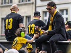 YB-Trainer Gerardo Seoane verteilt am Meisterumzug vom Lastwagen aus Autogramme. Neben ihm Betreuer mit der 13 auf dem Rücken - diese Zahl steht für YBs 13. Meistertitel. (Bild: Keystone/PETER SCHNEIDER)
