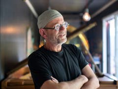 Das temporäre «Lattich»-Quartier zieht innovative Projekte an: Der Musiker Roman Rutishauser, aufgenommen in seinem «Container für Unerhörtes», hat seinen Arbeitsort auf das Areal beim St. Galler Güterbahnhof verlegt. Ein Holzbau auf der Brache bietet neu Arbeitsplätze für die Kreativwirtschaft. (Bild: KEYSTONE/GIAN EHRENZELLER)