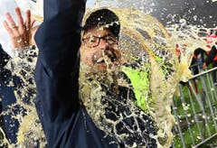 Die Freude über den Aufstieg in die 1. Bundesliga wird mit einer ordentlichen Bierdusche gefeiert: Union Berlins Trainer Urs Fischer. (Bild: Joerg Carstensen/dpa)