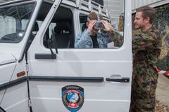 Daniel Seckler von der Schweizer Armee hilft Carlo Felder beim Anziehen der VR Brille, mit welcher er auf eine virtuelle Patrouillenfahrt gehen kann. (Bild: Boris Bürgisser, 1. Mai 2019)