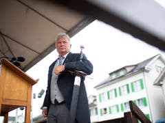 Mit dem Richtschwert als Symbol: Landammann Andrea Bettiga im Frack (Bild: KEYSTONE/GIAN EHRENZELLER)