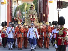 Der neu gekrönte thailändische König Maha Vajiralongkorn wird von seiner königlichen Garde auf einer Sänfte durch die Strassen der Hauptstadt Bangkok getragen. (Bild: Keystone/AP/SAKCHAI LALIT)