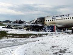 Löschschaum bedeckt die Rollbahn und das zerstörte Flugzeug. (Bild: KEYSTONE/AP Moscow News Agency)