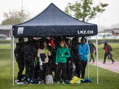 Leichtathleten schützen sich vor dem Niederschlag am Nationalen Frühjahrsmeeting auf der Leichtathletik-Anlage Allmend in Zug. (Bild: Patrick Hürlimann, Zug, 4. Mai 2019)