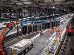 Ein Kran hievt die Anzeigetafeln bei der Stirn des Luzerner Bahnhofs zur Montage in die Höhe. (Bild: KEYSTONE/URS FLUEELER)