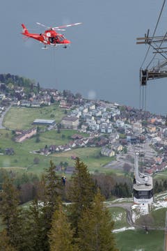 Ein Rega-Helikopter schwebt oberhalb einer Kabine der Klewenalp-Bahn. (Bild: Nadia Schärli, 8. Mai 2019)
