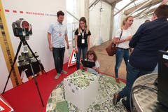 Leonie Szarka (Lernende) bei der Trigonet AG und Jochen Veitinger zeigen der kleinen Besucherin den Stand. (Bild: Roger Zbinden, 1. Juni 2019)