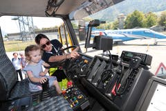 Helen Burri von der Pilatus-Betriebsfeuerwehr zeigt der kleinen Laura Meyer das Universal-Löschfahrzeug (ULF). (Bild: Roger Zbinden, 1. Juni 2019)