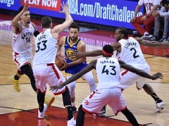 Umringt von gleich vier Spielern der Toronto Raptors sucht Golden States Topskorer Stephen Curry einen Ausweg. Mit 31 Punkten war er der beste Punktesammler der Warriors (Bild: KEYSTONE/EPA/LARRY W. SMITH)