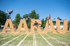 Geräteturnerinnen des STV Ballwil posieren auf dem Aarau-Schriftzug im Schachen. (Bild: Urs Flüeler/Keystone)