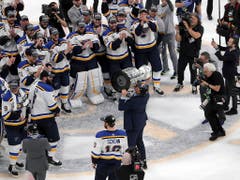 Cheftrainer Craig Berube küsst die Tropähe, die Spieler applaudieren dem Boss (Bild: KEYSTONE/AP/CHARLES KRUPA)