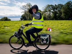 Viel Zeit für ein Lächeln und die Landschaft: einer der Teilnehmer, der am Wochenende mit anderen Velosolex-Liebhabern den Genfersee umrundete. (Bild: KEYSTONE/JEAN-CHRISTOPHE BOTT)
