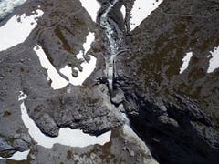 Erst als das Wasser sich durch die Schneemassen fressen konnte, konnte der See auf seinem gewohnten Weg ablaufen. (Bild: Stefan Simmen, Spiringen, 17. Juni 2019)