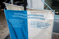 Eine Flagge mit den Namen der letzten Kantonsratspräsidentinnen und Kantonsratspräsidenten steht neben dem Rednerpult.