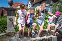 In Zug fand am 24. Juni der traditionelle Chriesisturm statt. Diese Kinder gönnen sich eine Abkühlung im Brunnen. (Bild: Christian H. Hildebrand)