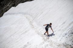 Abkühlung auf 2502 Metern über Meer: Ein junger Besucher wandert durch ein Schneefeld.