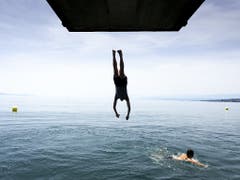 Kopfüber in den kühlen Genfersee. Die Temperaturen übertrafen am Mittwoch an verschiedenen Messstationen die Marke von 35 Grad. Einige Orte meldeten Allzeit-Temperaturrekorde. (Bild: KEYSTONE/SANDRA HILDEBRANDT)