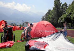 Trotz grosser Hitze bauen viele Gigathleten ihr Zelt bereits am Mittag auf. Bis zum Abend entsteht hier in Sarnen das rote Gigathlon-Camp.