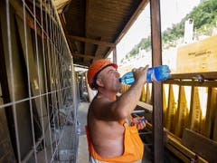 Viel trinken: Ein Arbeiter auf einer Strassenbaustelle im Tessin versorgt sich mit Wasser. (Bild: KEYSTONE/FRANCESCA AGOSTA)