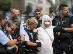 Polizisten führen am Montag Klimaaktivisten ab vor dem Eingang der Credit Suisse auf dem Paradeplatz in Zürich. (Bild: KEYSTONE/ENNIO LEANZA)