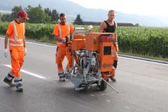 Der Bautrupp bringt die Markierungen auf eine Länge von 410 Metern an.