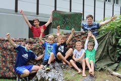 Die mittleren Knaben mit der Gruppenfahne bei der selbstgebauten Hütte. (Lagerbild: Pfarreilager Neuenkirch, 12. Juli 2019)