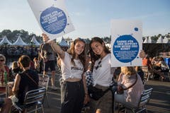 Paulina Appel (links) und Sae Fontana versuchen, die blauen Pins an die Besucher zu bringen. (Bild: Nadia Schärli, Luzern, 19. Juli 2019)