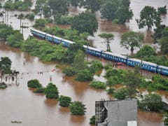 Wegen Hochwassers blieb ihr Zug stecken. Nach stundenlangem Warten wurden 800 Passagiere eines Schnellzugs in Indien von der Marine in Sicherheit gebracht. (Bild: KEYSTONE/AP Indian Navy)