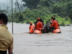 Die Bahnreisenden wurden in Rettungswesten mit Schlauchbooten durch das trübe braune Wasser abtransportiert. (Bild: KEYSTONE/EPA/DIVYAKANT SOLANKI)