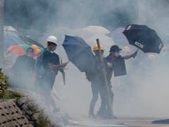 Schirme im Tränengasnebel: in Hongkong sind die Proteste am Samstag erneut eskaliert. (Bild: KEYSTONE/AP/BOBBY YIP)