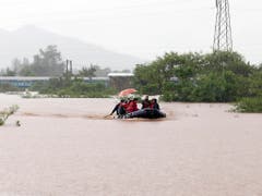 Rettung per Boot: fast 900 Passagiere befanden sich im Südwesten Indiens in einem Zug, der in Monsunfluten stecken blieb. (Bild: KEYSTONE/AP/MAHESH MORE)