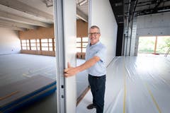 Gemeinderat Christian Würth demonstriert, wie aus dem Multifunktionsraum eine Bühne wird.