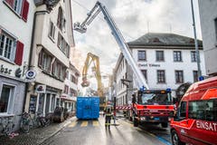 Steckborn TG - Beim Grossbrand in der Altstadt von Steckborn vom 21. Dezember 2015 wurden sechs Gebäude zerstört. Die Feuerwehren von Steckborn, Frauenfeld, Kreuzlingen und Weinfelden waren vor Ort. Nachmittags (Bild) war der Brand noch nicht vollständig gelöscht; zwei Häuser wurde mit dem Bagger teilweise abgerissen.