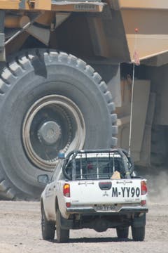Chile 2011. Zirka 400 Pick-Up's sind auf dem Abbaugelände der Mina Radomiro Tomic unterwegs. Gerne lassen sie den gewaltigen, mit 400 Tonnen Gestein beladenen Mining Trucks mit ihren 4 m hohen Rädern den Vortritt, respektvoller Abstand ist oberste Pflicht. Die Dumperfahrer sehen im Staub oft nur den 4 Meter hohen Wimpel an den Kleinfahrzeugen, somit ist er die Lebensversicherung. Wer vergisst seinen Wimpel zu montieren ist mit einer fristlosen Kündigung konfrontiert. (Bild: Kari Feierabend)