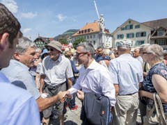 Bundesrat Ignazio Cassis (Mitte vorne) beim Händeschütteln am Apéro mit der Bevölkerung des Kantons Nidwalden. (Bild: Keystone/URS FLUEELER)