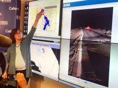Die Seismologin Lucy Jones von der US-Erdbebbenwarte zeigt eine Übersicht des Erdbebens vom Donnerstag und der darauffolgenden Nachbeben. Rechts das Bild eines Risses in einer Strasse nach dem starken Beben vom Freitag. (Bild: KEYSTONE/AP/JOHN ANTCZAK)